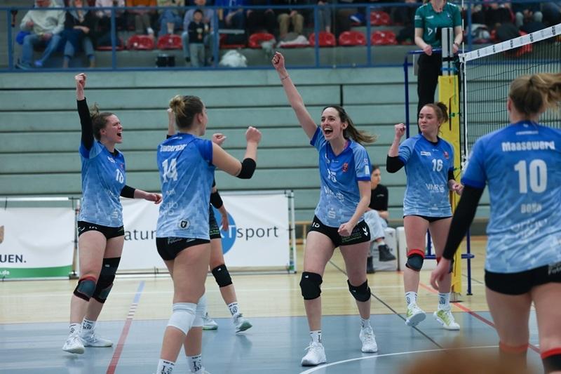 Voller Jubel: Volleyballspielerinnen feiern einen Punktgewinn in einem Sportevent, umgeben von Zuschauern.
