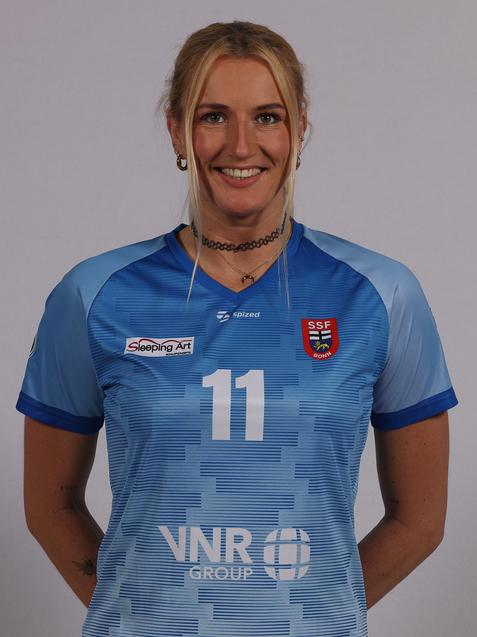 L&auml;chelnde Sportlerin in hellblauem Trikot mit der Nummer 11, pr&auml;sentiert auf neutralem Hintergrund.