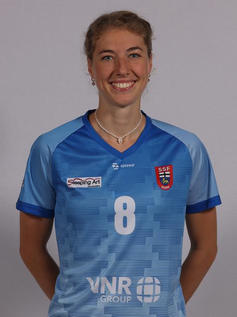 L&auml;chelnde Frau in blauem Sporttrikot mit der Nummer 8, vor einem einfarbigen Hintergrund.