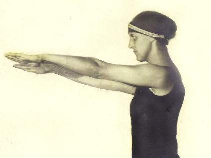 Frau in Badeanzug steht mit ausgestreckten Armen am Beckenrand, bereit zum Sprung ins Wasser.