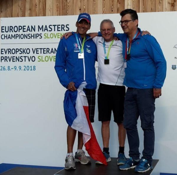 Drei Medaillengewinner l&auml;cheln zusammen auf dem Siegertreppchen der European Masters Championships in Slowenien.