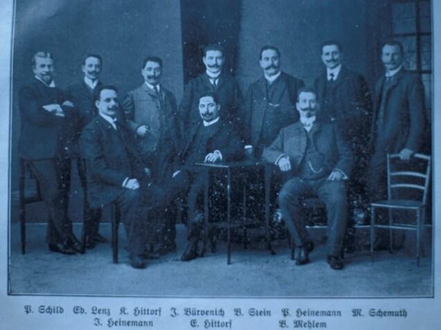 Historisches Gruppenfoto des ersten Vorstands nach der Gr&uuml;ndung 1905, M&auml;nner in Anz&uuml;gen posieren vor einer Wand.