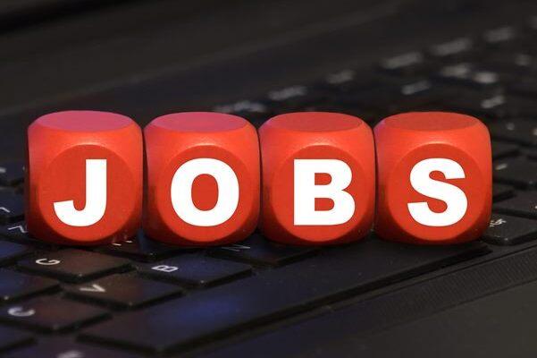 Rote W&uuml;rfel mit dem Schriftzug &bdquo;JOBS&ldquo; auf einer schwarzen Laptop-Tastatur.