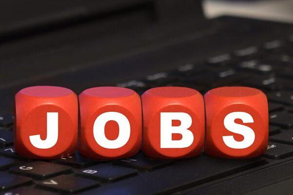 Rote W&uuml;rfel mit dem Schriftzug &bdquo;JOBS&ldquo; auf einer schwarzen Laptop-Tastatur.