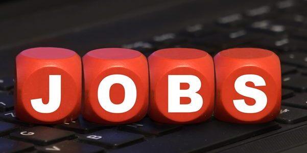 Rote Würfel mit dem Schriftzug „JOBS“ auf einer schwarzen Laptop-Tastatur.