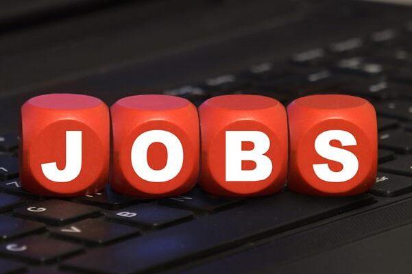 Rote W&uuml;rfel mit dem Schriftzug &bdquo;JOBS&ldquo; auf einer schwarzen Laptop-Tastatur.